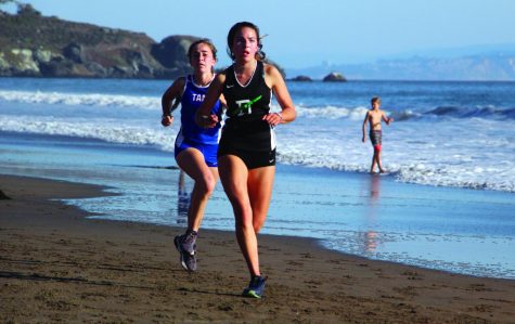 On September 12 at Stinson Beach, Junior Ava Podboy keeps her lead ahead of a Tam runner.
