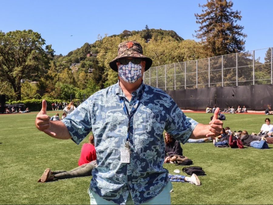 Campus supervisor Rich Blasewitz throws up two shakas for the camera on the baseball field during lunch.