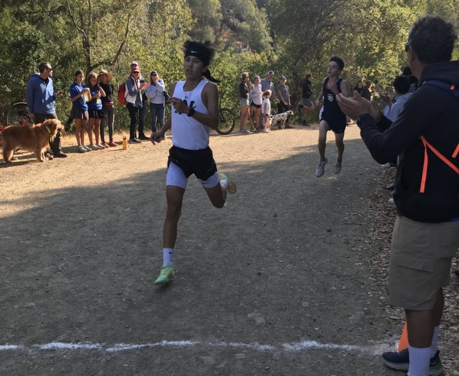 Junior+Barret+Acker+lunging+towards+the+finish+line%2C+with+fans+cheering+him+on.