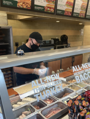 Ramy Iskander, manager of Subway’s location in the Red Hill Shopping Complex, making a sandwich for a customer.