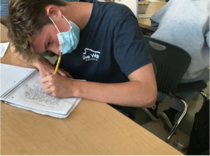Sam Sobieraj studying and wearing a mask in an AWHS classroom. 