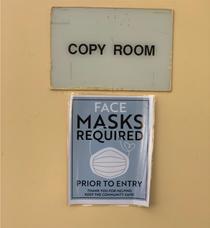 Sign reading “Face masks required prior to entry” pictured at the Brookside Elementary School Copy Room.