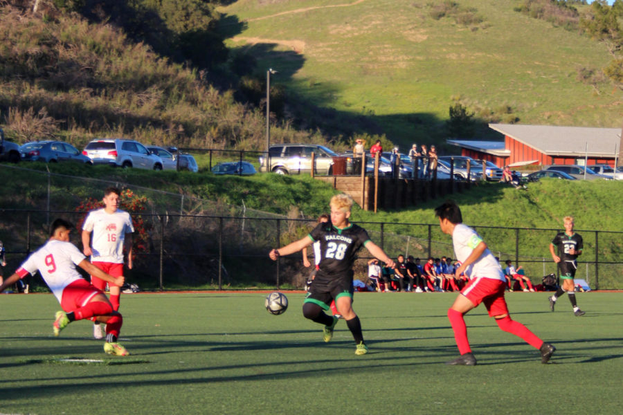 Junior Henry Escobar attempts to dribble past multiple San Rafael High opponents. 
