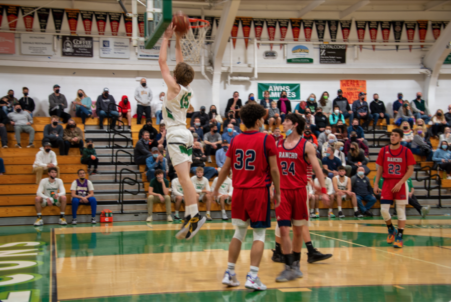  Cal Amborn breaks away from the opponent’s defense and jumps up to score on a layup, raising AWHS lead by a point.