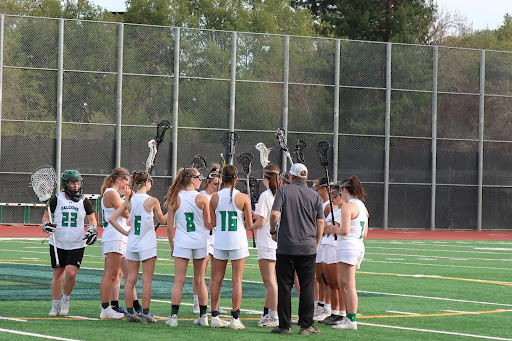 AWHS varsity girls lacrosse team huddles around Assistant coach Ted Hellman during their game against San Rafael high school.