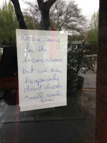A note taped on the door of the outside of Fradelizo’s announcing their temporary closure due to fire in between a wall bordering neighboring business Bah mi Bah.