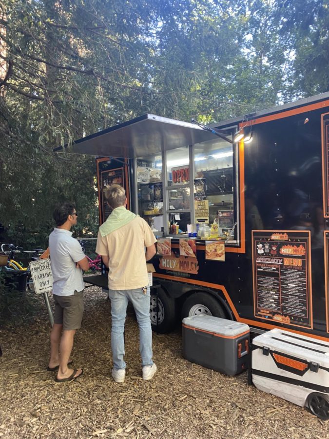 Two customers of Holy Chile Mole reviewed the food trucks breakfast menu white waiting to order.