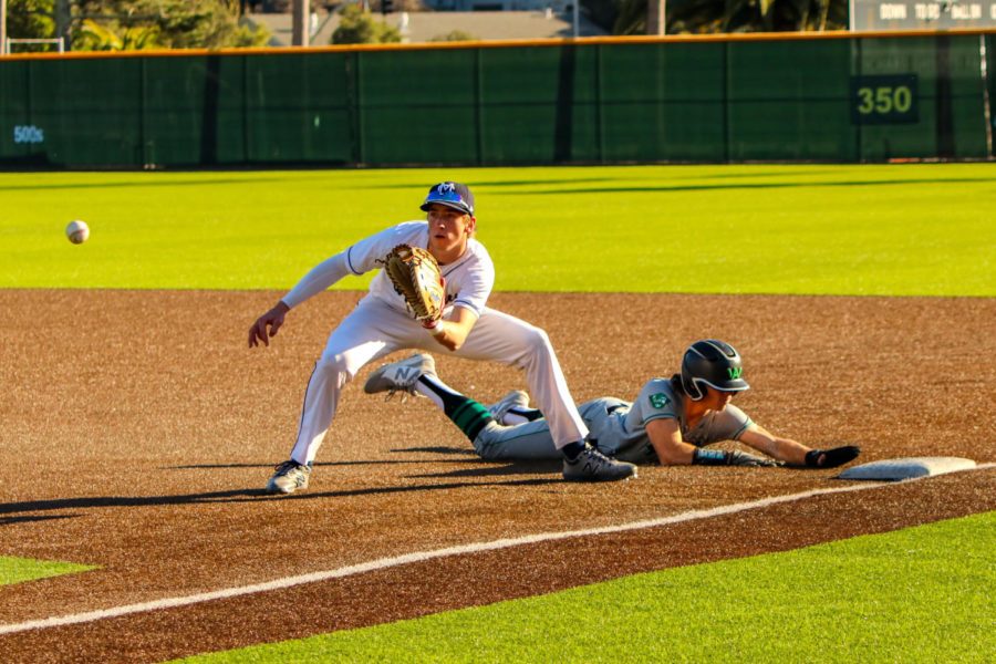 Junior Charlie Scola slides back to first base avoiding a pick off attempt.