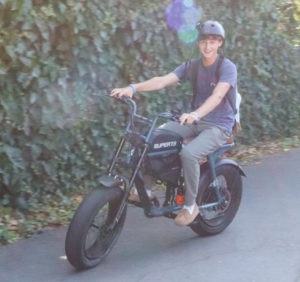 Junior Max Lefferts rides his e-bike on campus on Thursday.