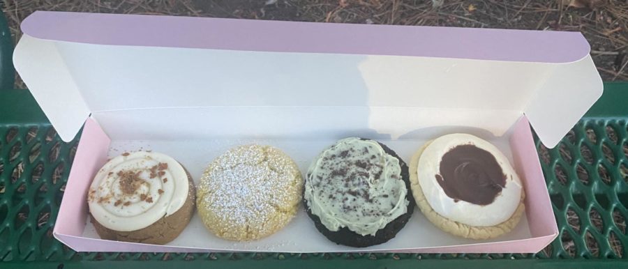 Crumbl cookie’s 11/24 lineup of Gingerbread Cake, Lemon Crinkle, Green Mint ft. Andes®️, and Boston Cream Pie (left to right) colorfully fill up Crumbl’s signature pink box. 