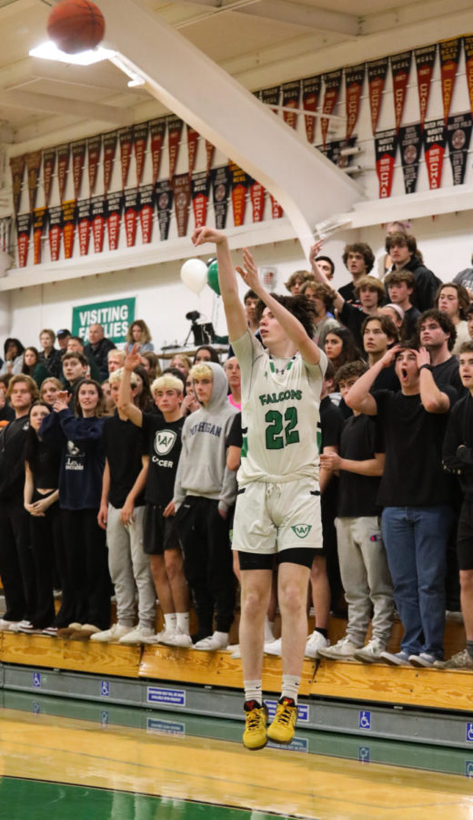 Junior guard Alex Martikan shoots a three-pointer in front of the Archie Williams student section.