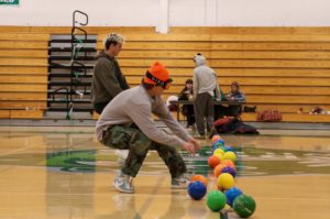 Senior Frankie Fradelizio lunges toward a dodgeball during the Snow Day dodgeball game.