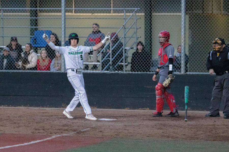 Junior Sam Black flips his bat and celebrates as Redwood pitcher Rex Solle walks someone home, winning the game for Archie Williams.
