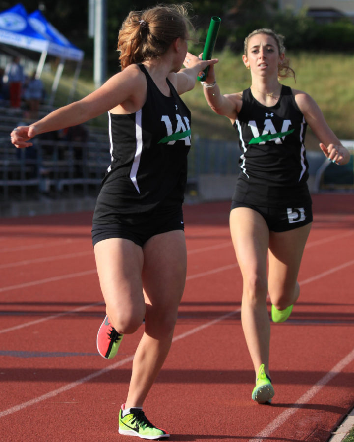 Junior Ally Greenwald hands the baton off to fellow junior Jane Adams during the 4 by 800 meter MCAL Championship race Saturday May 6. They would go on to shatter the Archie Williams school record with a time of 10:08.
