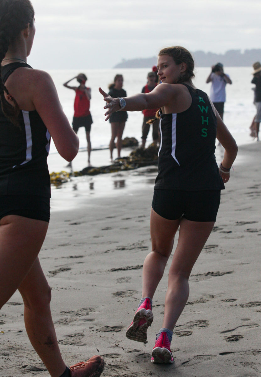 Senior Taylor DeNitto looks back for the high five hand off as her teammate senior Jasmin Desruisseau finishes her leg of the race.