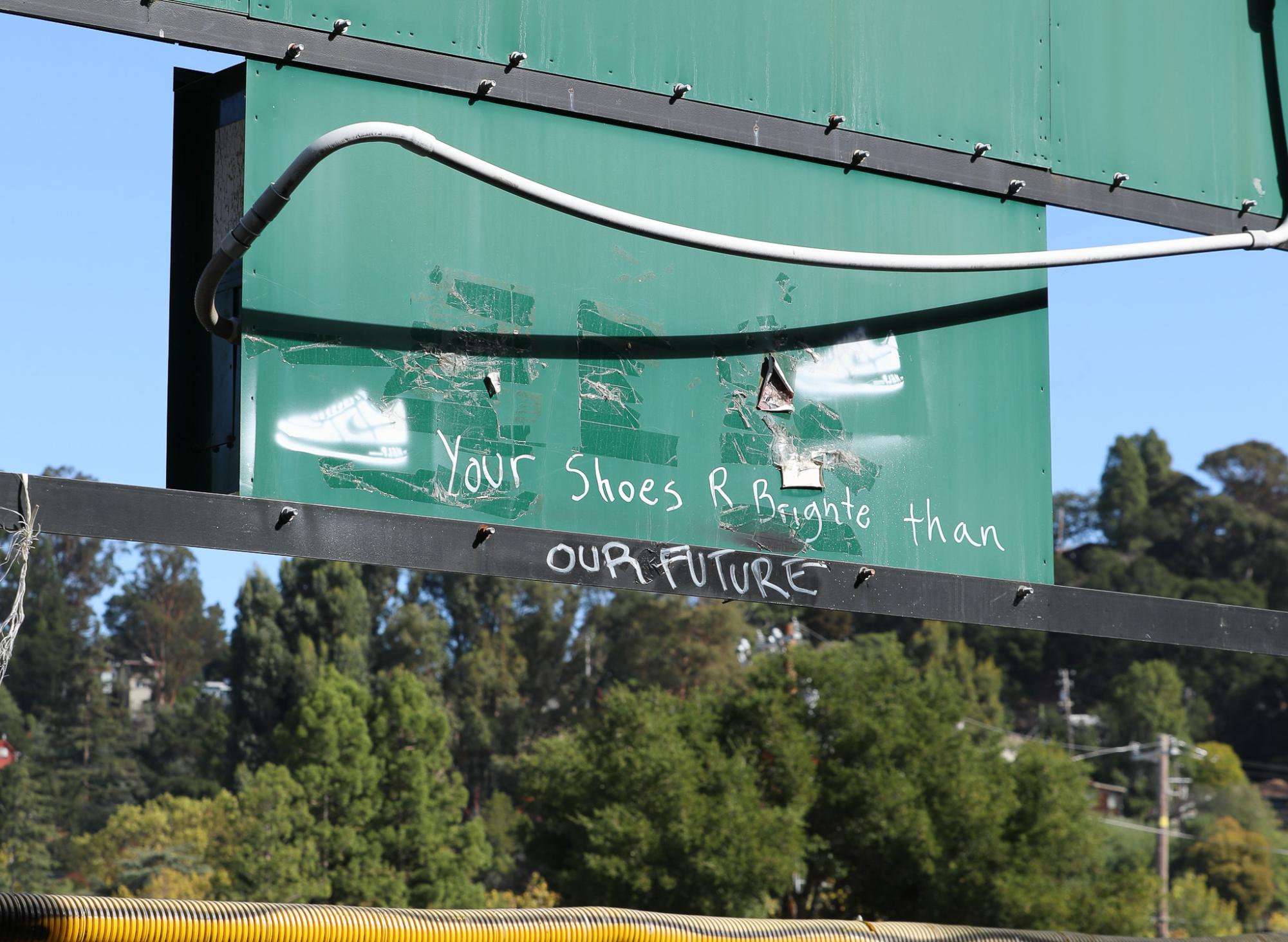 Graffiti by an unknown vandal on the back of Contratti Parks scoreboard reads: Your shoes R Brighter than our FUTURE. 