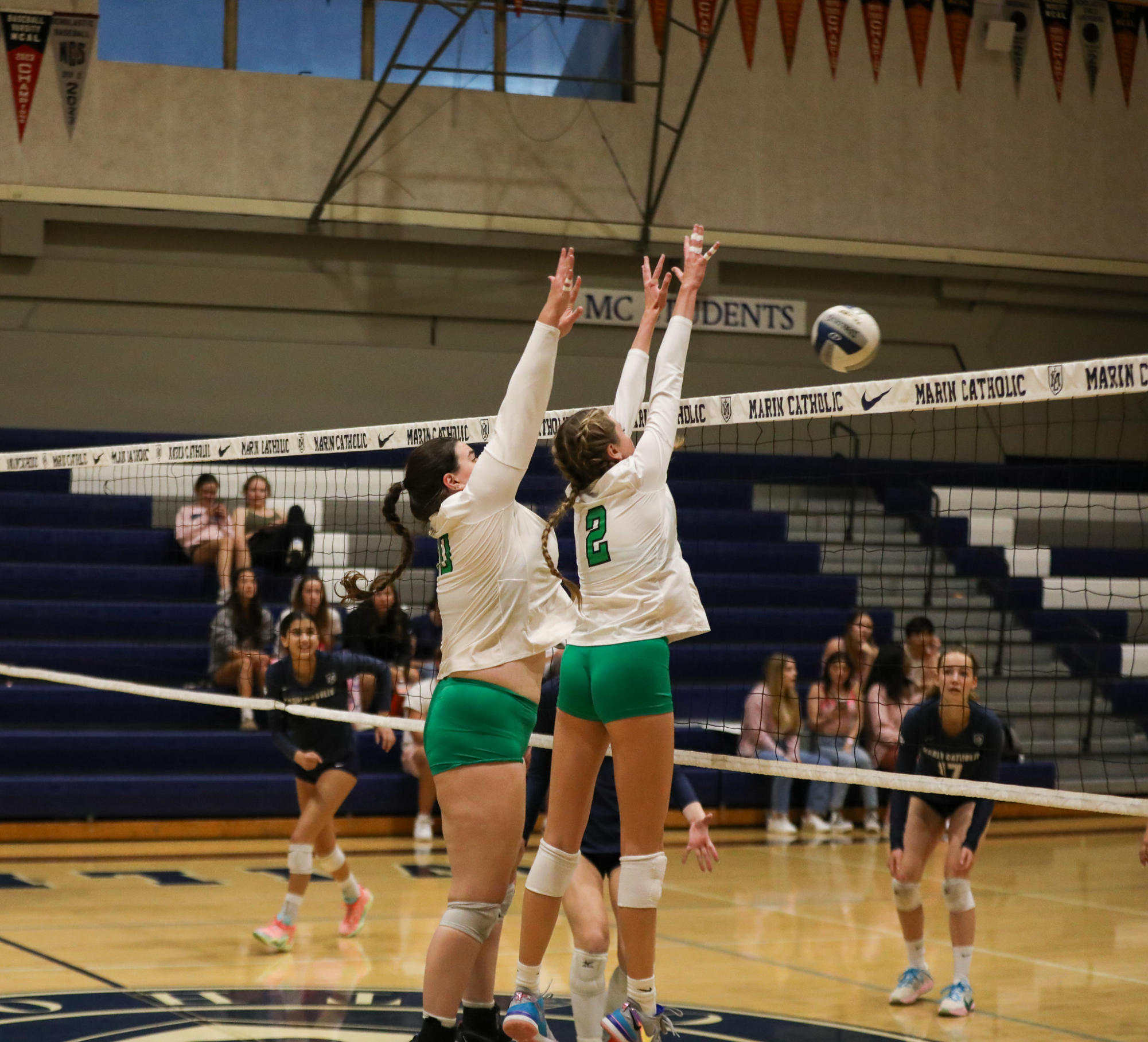  Seniors Katie Griffiths and Reese Fraser block the incoming spike from the  Wildcats. 