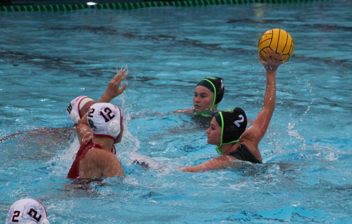 Senior Cate Logan looks to shoot the ball past the Redwood defenders.