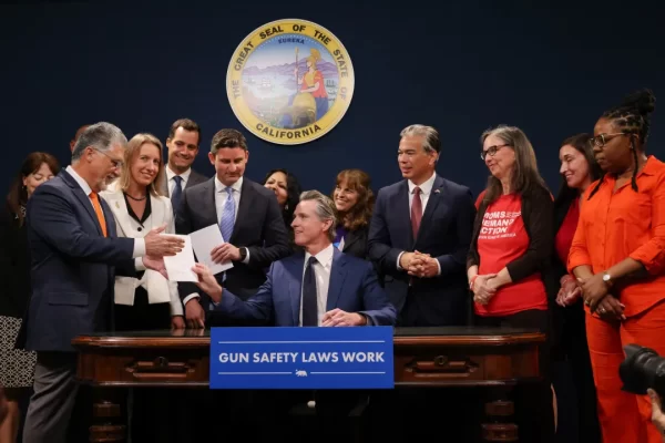 Governor Gavin Newsom signs 23 new gun safety laws into California law, with representatives from gun safety advocacy groups. 