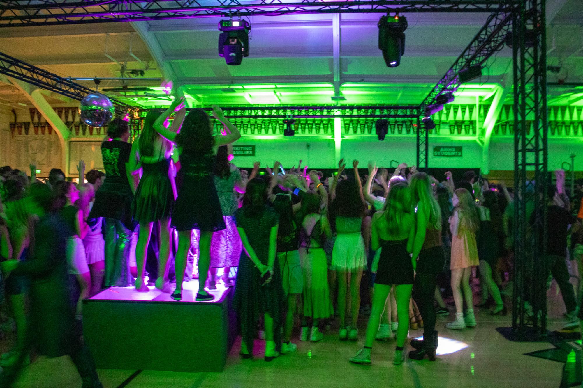 Archie Williams students put their hands in the air on the dance floor at the Homecoming dance. 