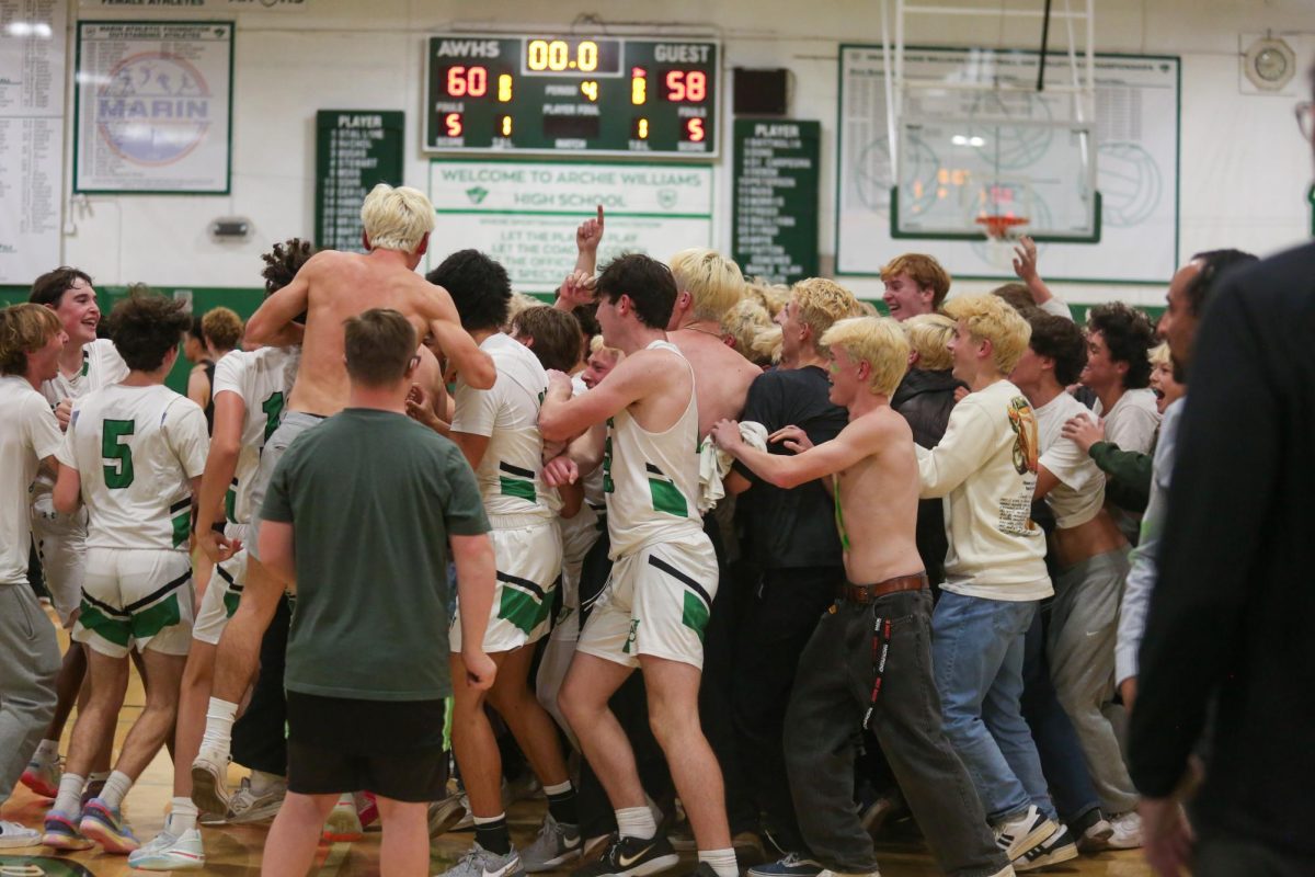 Archie Williams spectators storm the court following sophomore center Alex Hamblets buzzer beater game winner to edge out San Rafael 60-58 Tuesday, Dec. 12, 2023. 