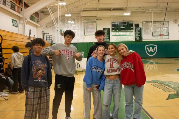 Freshman Bart Hernandez and Nate Greenberg pose with Sophomores Brian Wright, Ellen Winter, August Ehmann, and Ellery Ford dressed in their college merch. 