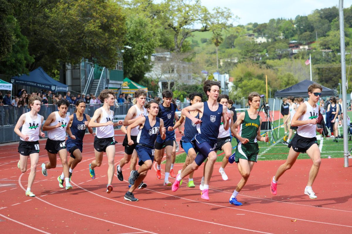 The boys varsity 1600 meter race takes off from the starting line, featuring a strong pack of Archie Williams runners.