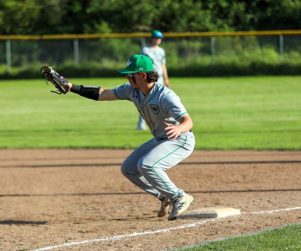 Senior first baseman Ethan Frankel squats down to catch the ball.
