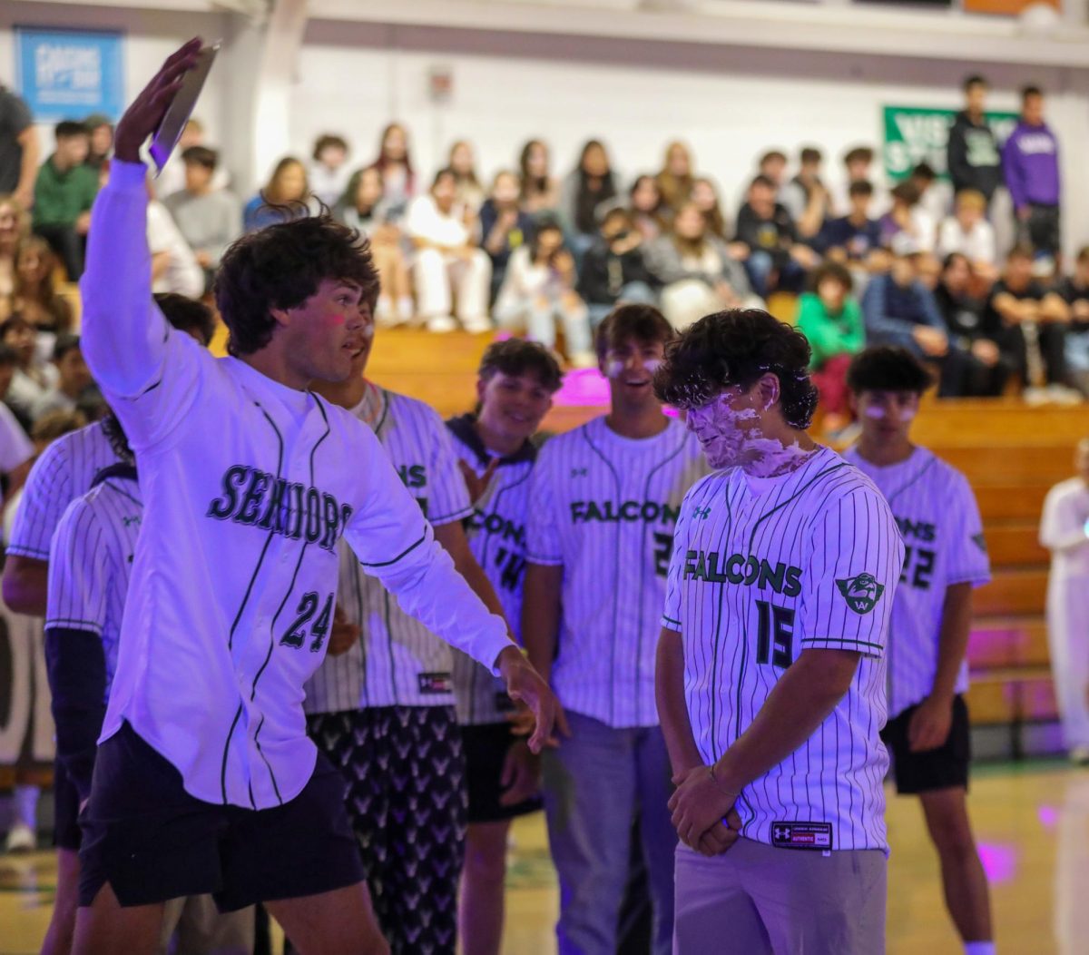 Senior Nicholas Lillevand pies freshman baseball player Solly Ojalvo during the blacklight rally.