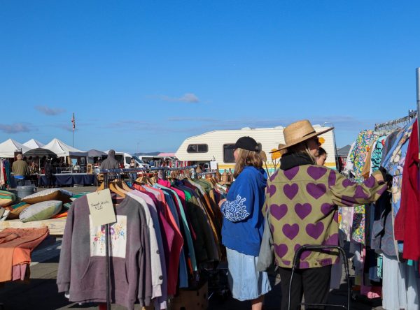 Alameda Flea Market customers sort through a rack of vintage sweatshirts.