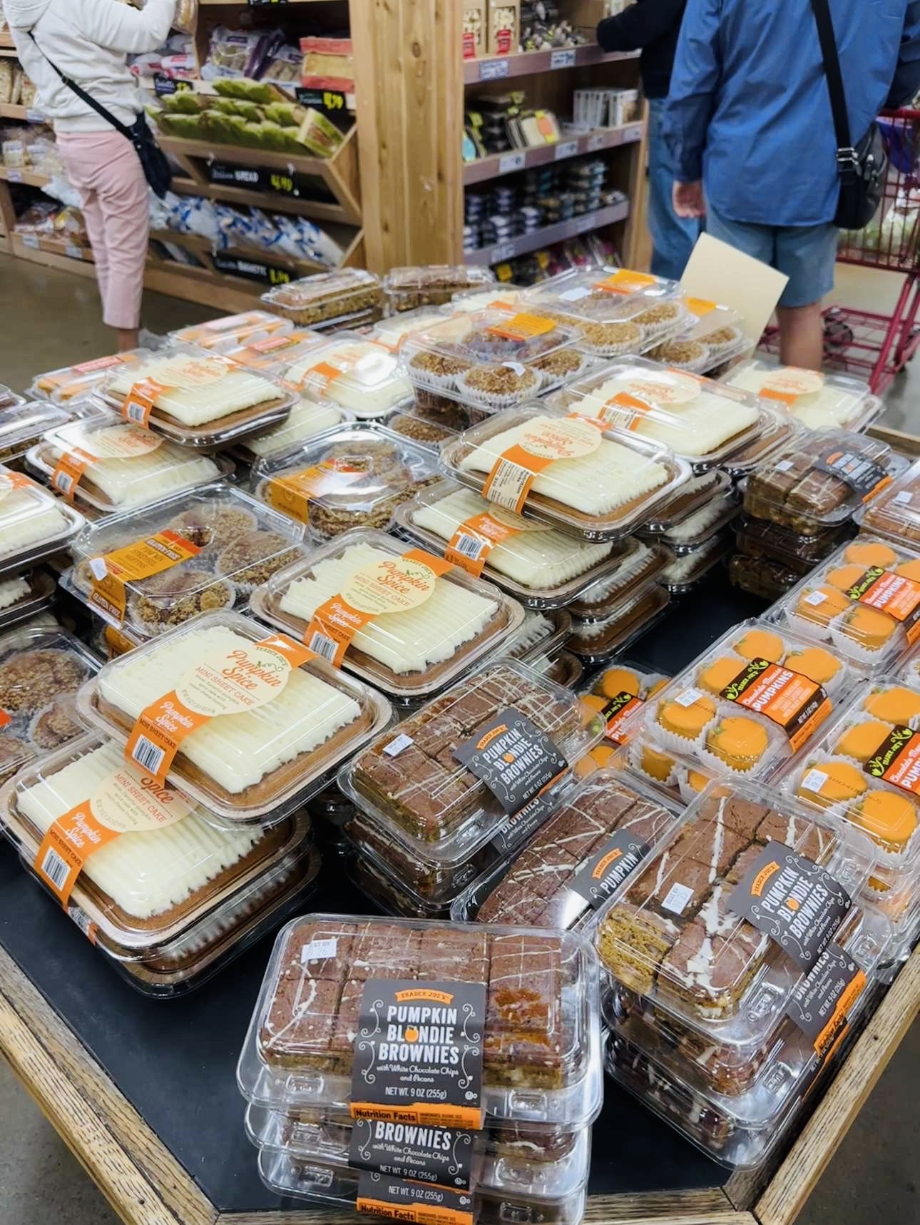 A seasonal display at Trader Joe's presents pumpkin cake, muffins, and brownies. 