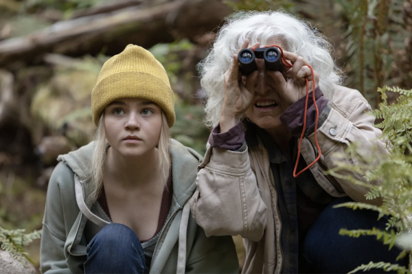 Penelope (Megan Stott) diligently watches tree loggers alongside environmental scientist Alana (Krisha Fairchild).