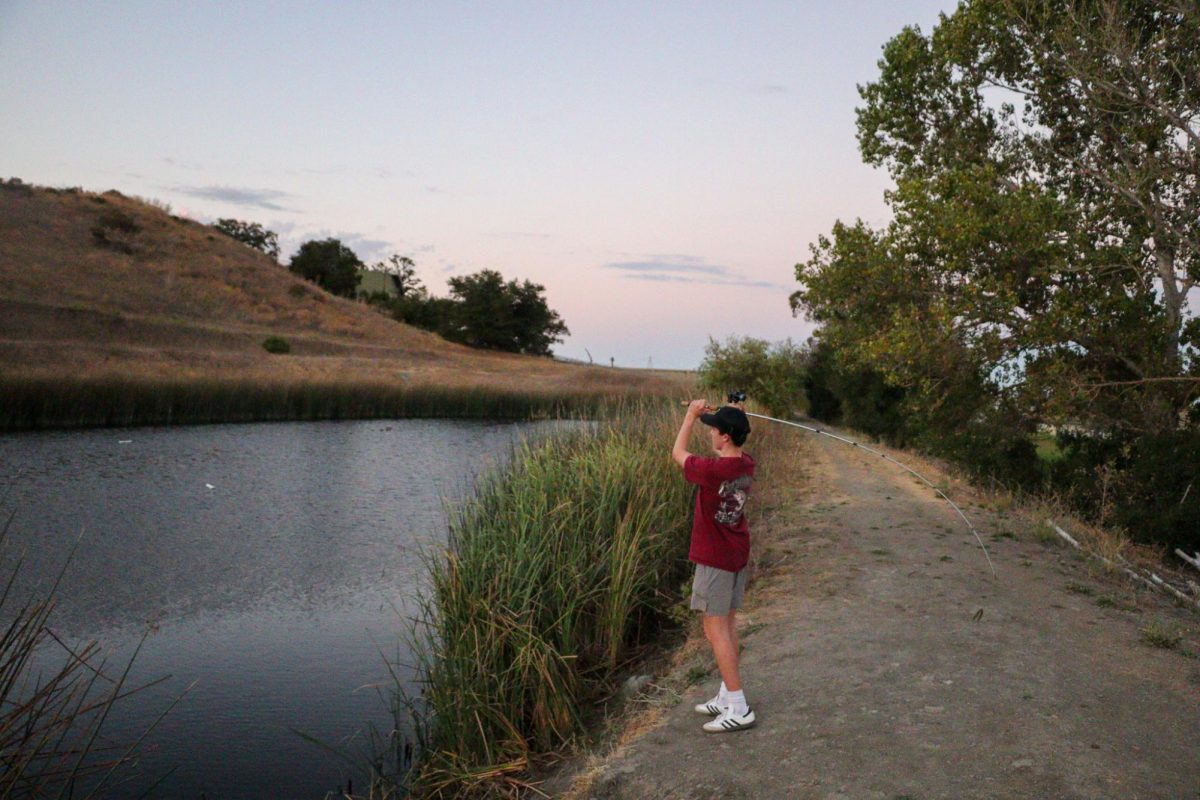 Junior Isaac Terry casts out at the McInnis Park pond.