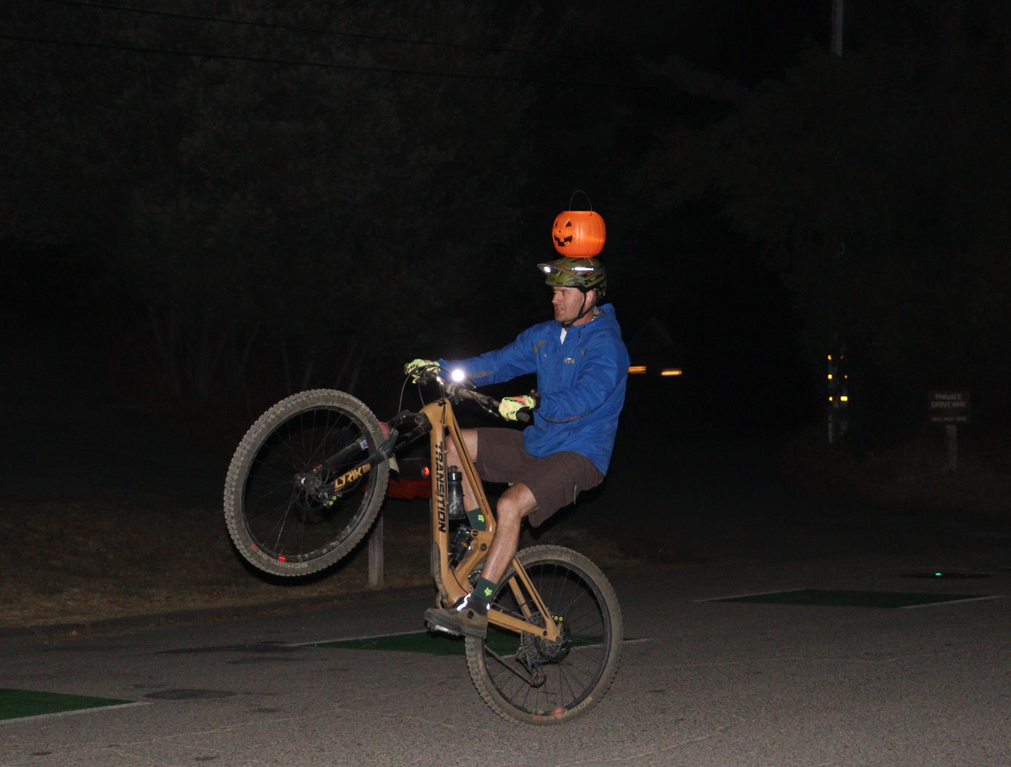 A cyclist wheelies down Butterfield Road after descending from the 680 trail. 