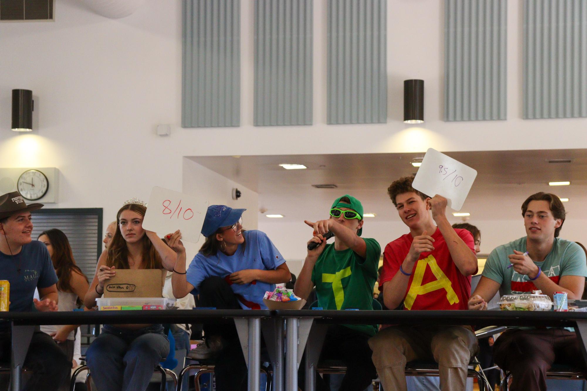 Judges Caroline Lozaw, Jasper Cohen, Ben Gross, Logan Burke, Donavan Traub, and Caelan O'Neill score contestants costumes.