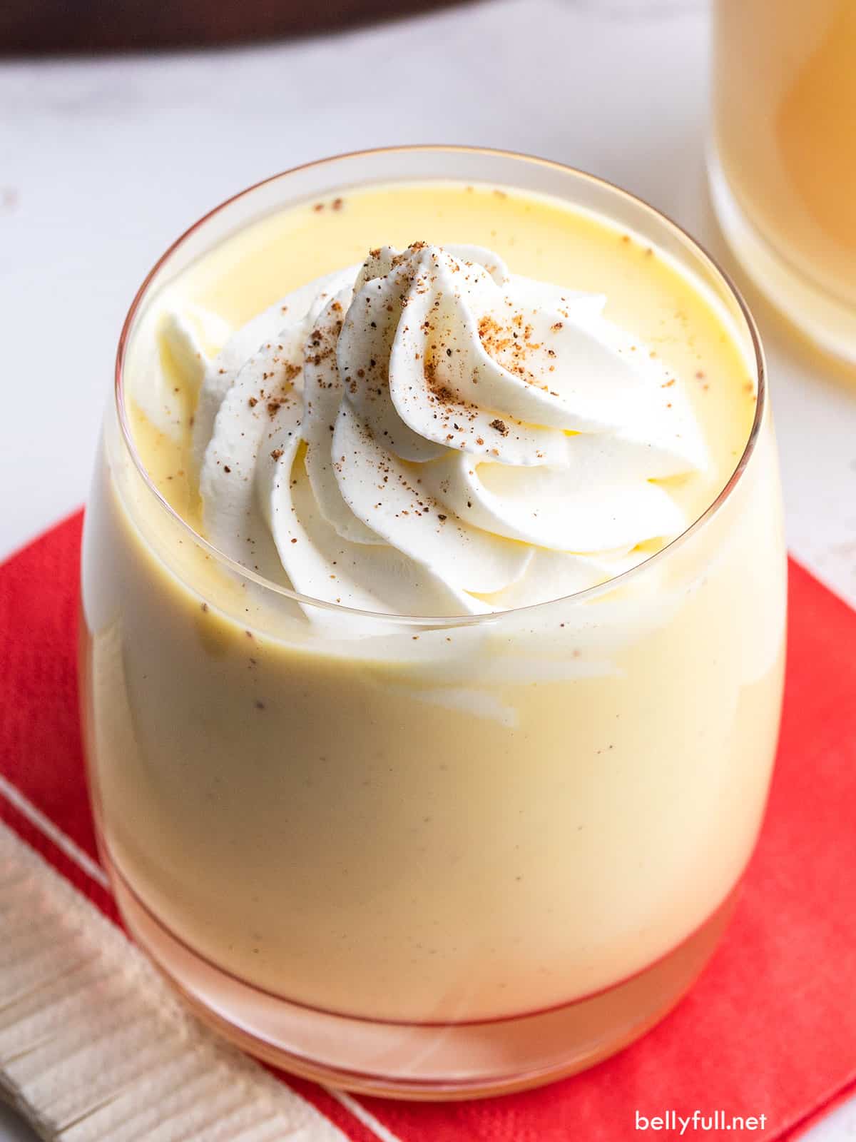 Thick creamy eggnog with specks from nutmeg topped off with whipped cream and cinnamon. (Courtesy of bellyfull.net)