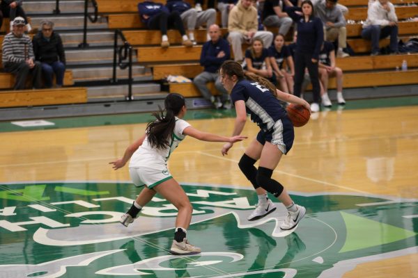 Junior Kaiya Chiu plays tough defense on a Marin Catholic Wildcat as she dribbles up the court.