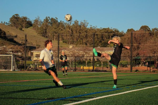 Senior Nolan Kriessmann passes the ball above an opponents head.