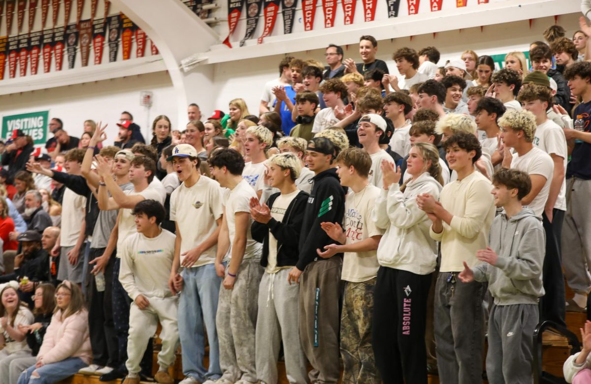 The Archie Williams student section supports the basketball team, dressing in white for the games theme of "white-out."