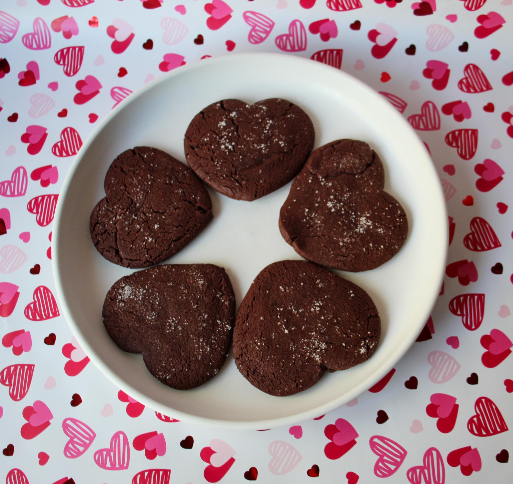 Five heart shaped red velvet cookies dusted with salt and sugar.