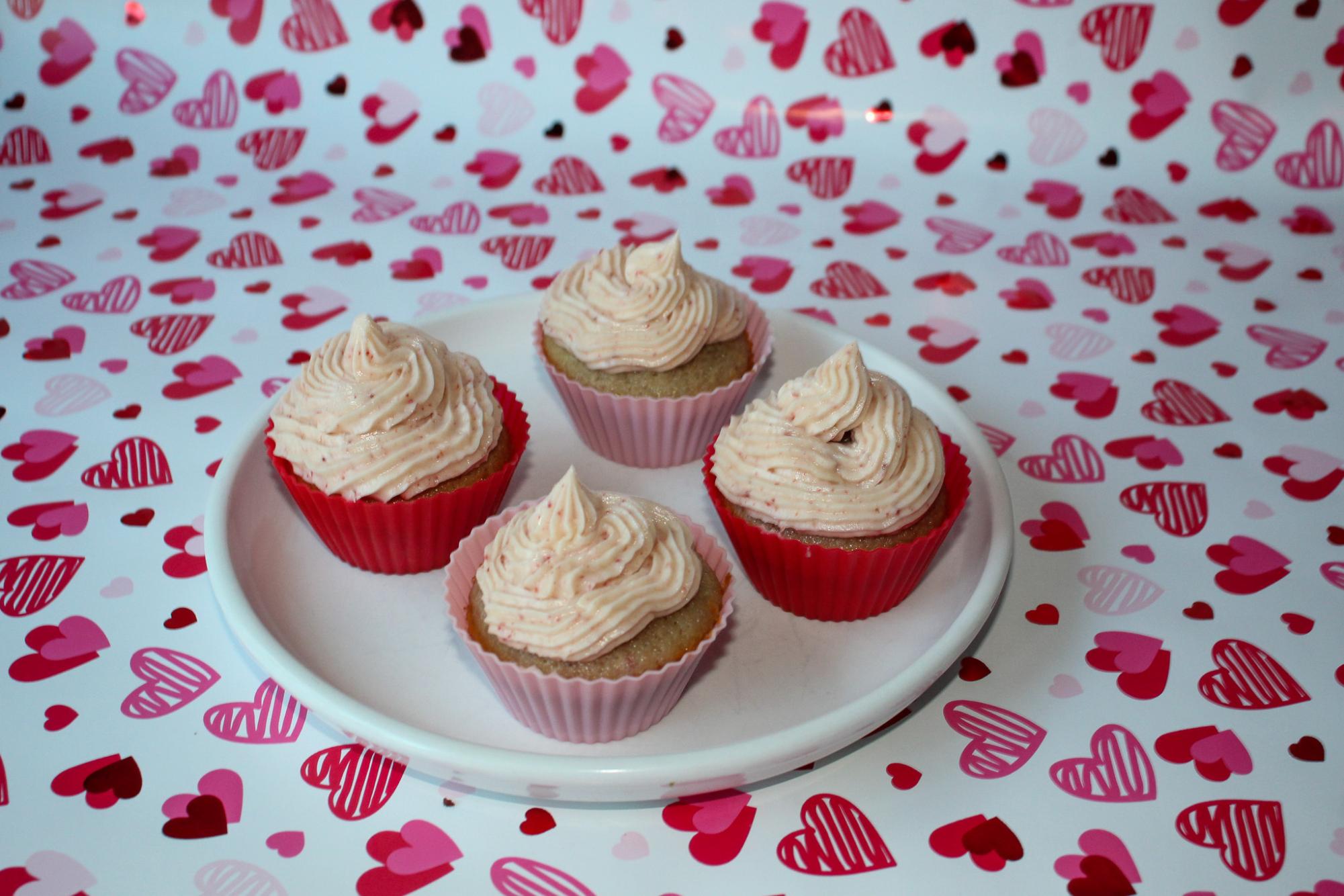 Four white chocolate strawberry cupcakes decorated and awaiting enjoyment.