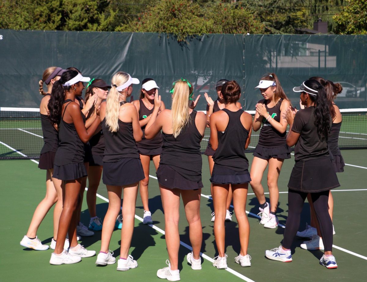 Archie Williams girls tennis team do the Falcon chant while warming up.

