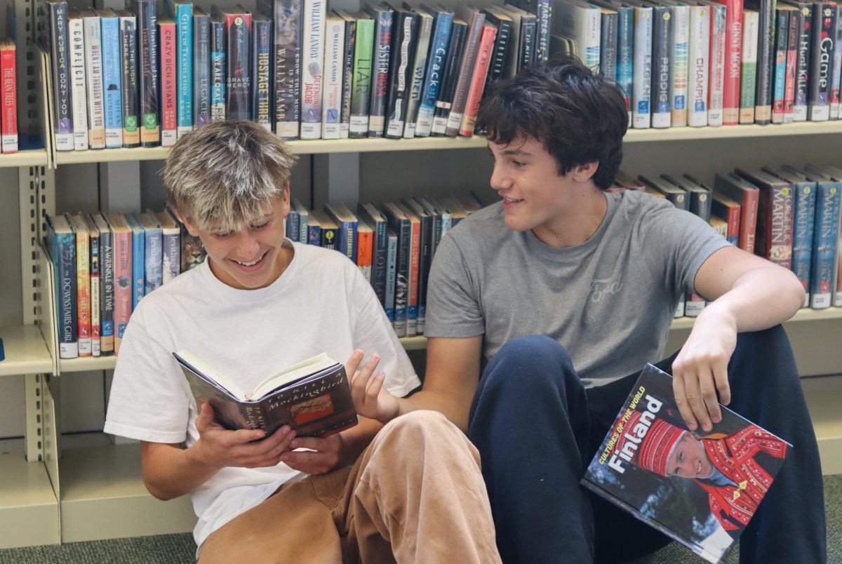 Freshmen Shepard Galmarini and Henry Faye read together in the school library.