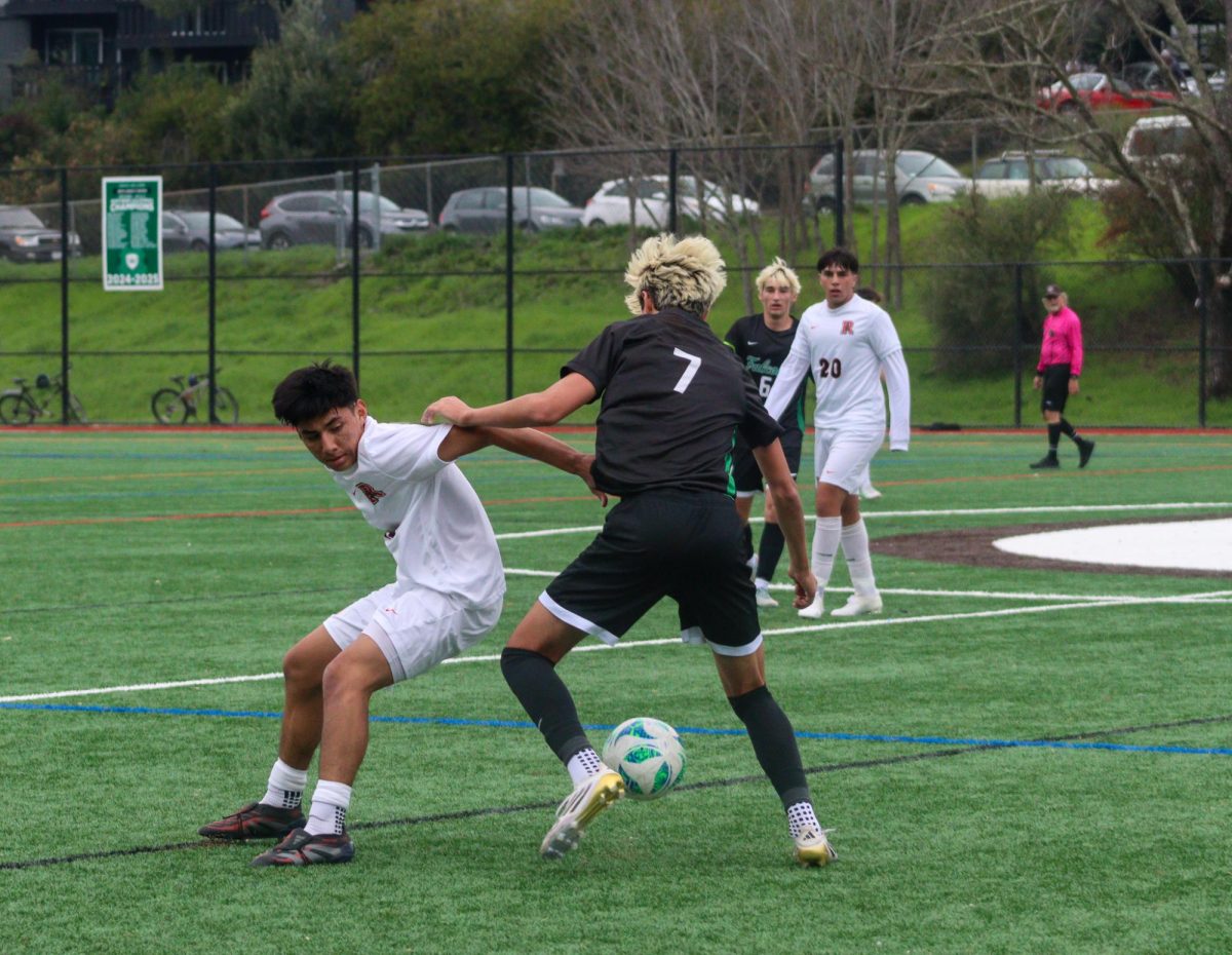 Junior Henry Miller battles an opponent for possession of the ball.